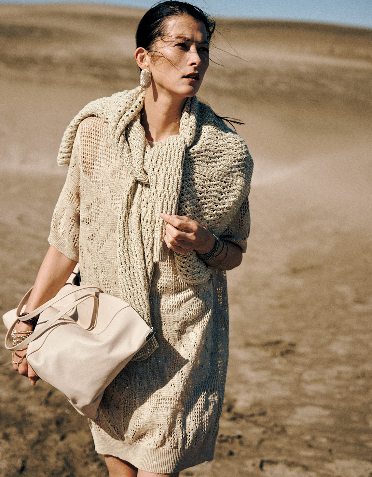 アンジェラ・レイノルズさん ワンピース・肩に掛けたカーディガン・ピアス・ブレスレット・バッグ（ブルネロ クチネリ ジャパン）