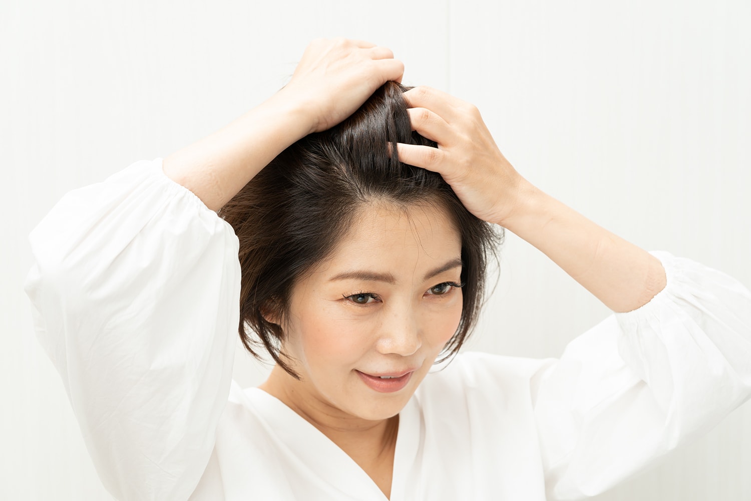 前髪とフロントの髪はワックスのついた手のひらでかき上げる。