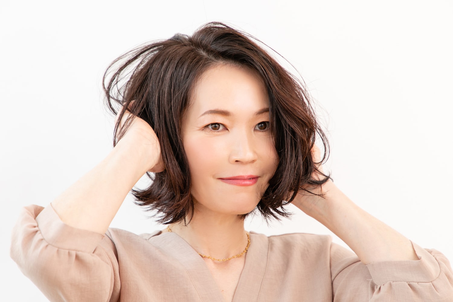 手のひらでバームとオイルを混ぜ、中間から毛先にもみ込む。毛先が外ハネになるように、ランダムに動きをつけて完成。