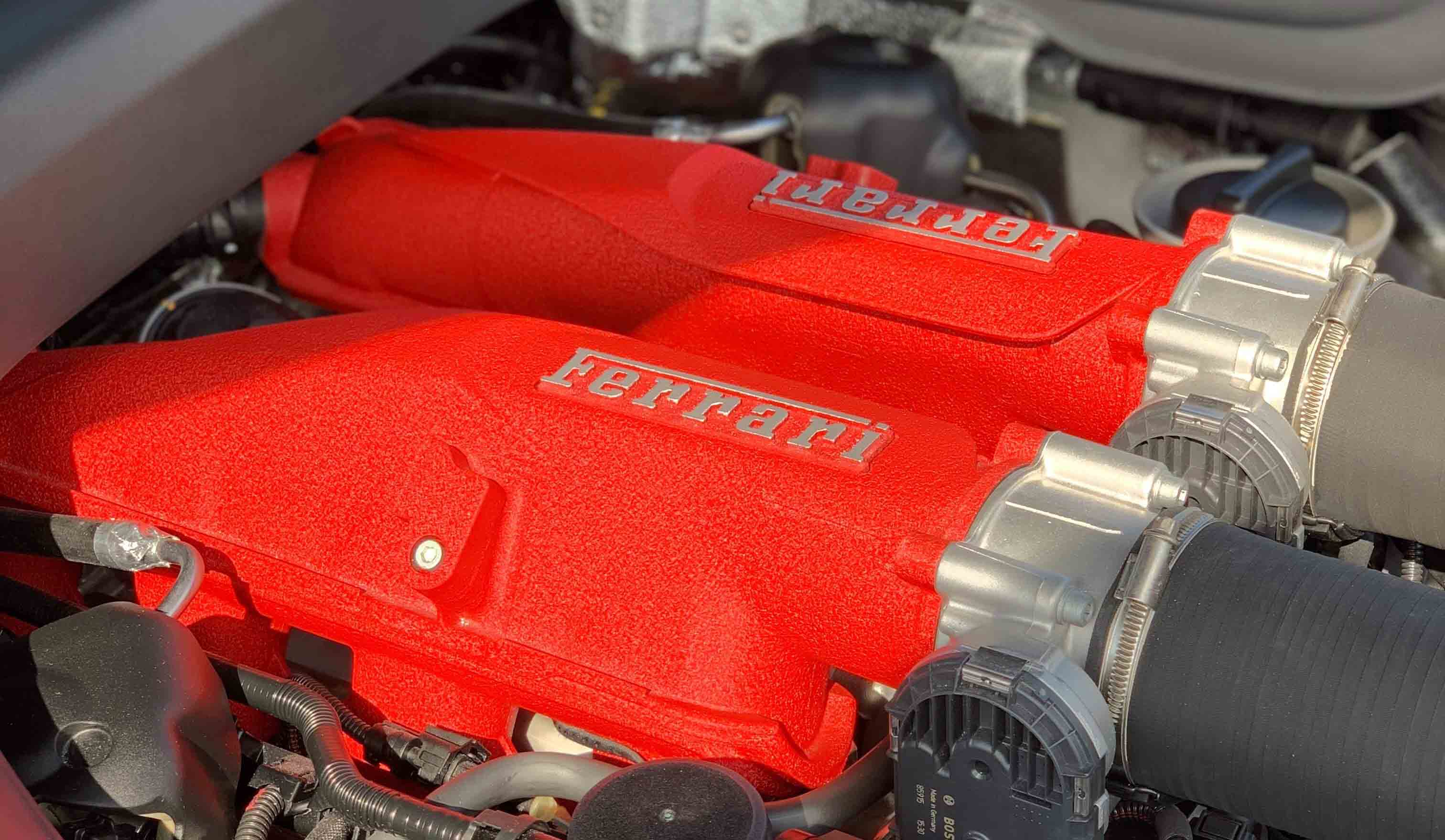 車体前方に搭載されたV8エンジンは、キャビン寄りのレイアウト(いわゆるフロントミッドシップ)。赤い結晶塗装を施した吸気ダクトが美しい。
