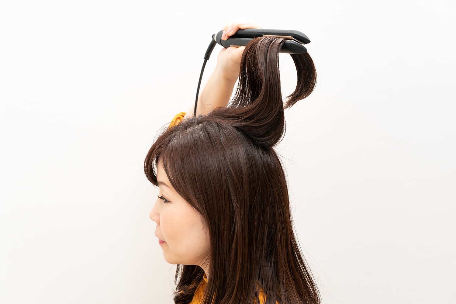 サイドと同様、持ち上げるようにかけるのがポイント。髪の表面も内側にもすべてアイロンをかけることで、髪全体が艶やかに。