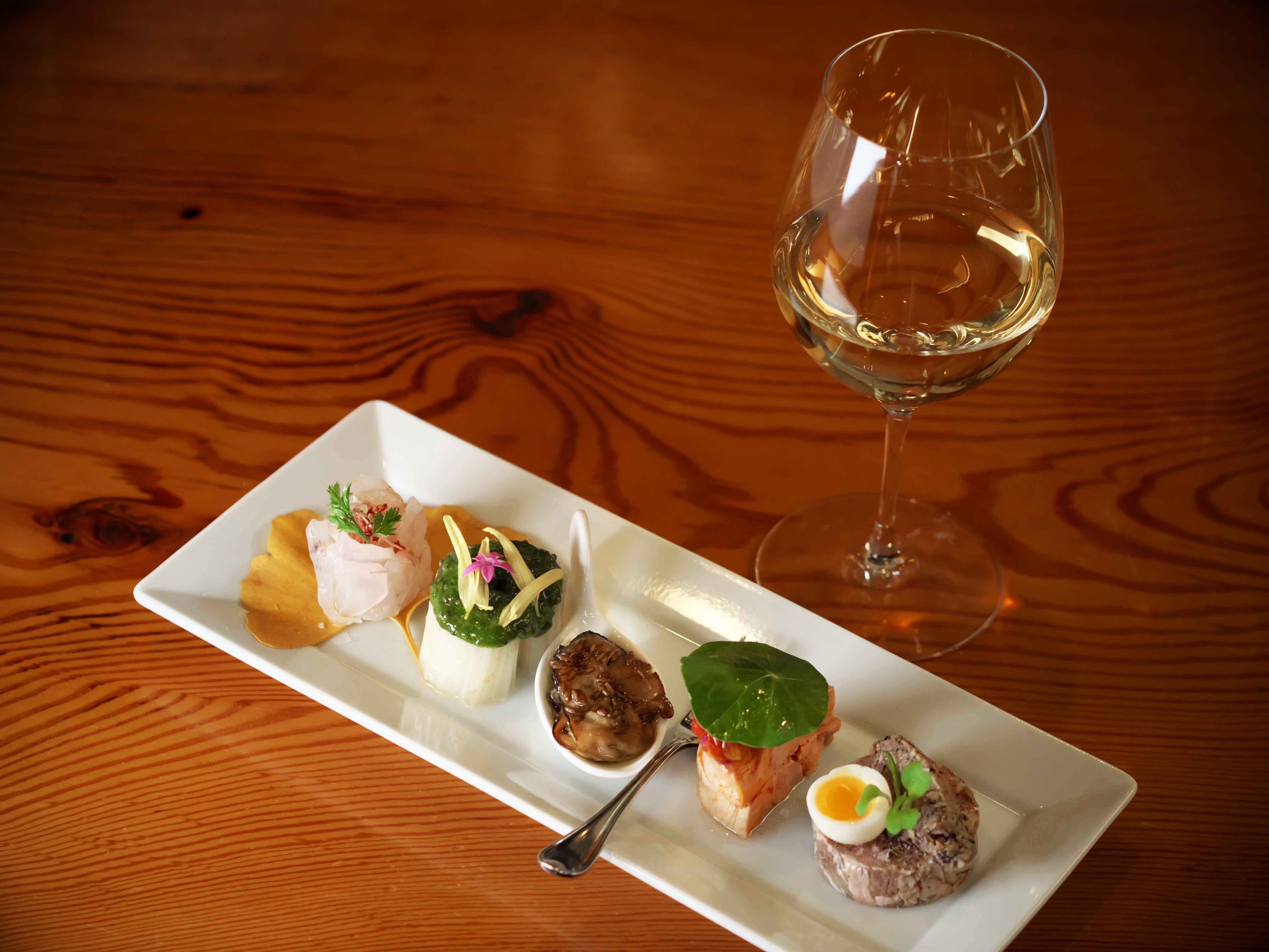 オードブル盛り合わせ(一人前)¥2,500。パテやカルパッチョをはじめ、一番いい状態の食材をつかったオードブルが5種。12月は三重産の牡蠣やクエ、下仁田ネギなど、この時期ならではの美味がいただける。グラスワインは¥800~。