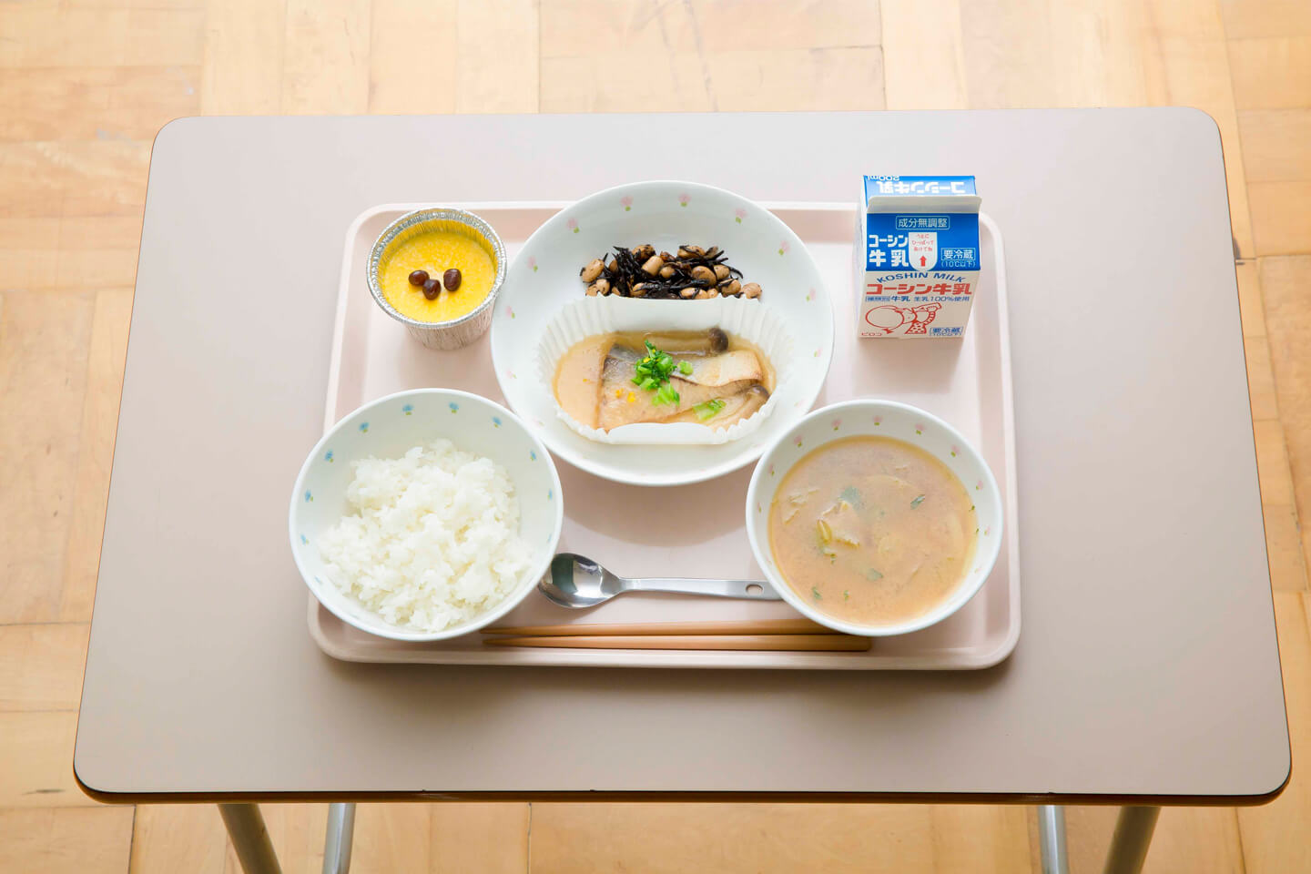 学校机の上に乗せたお盆に並ぶ和食の給食