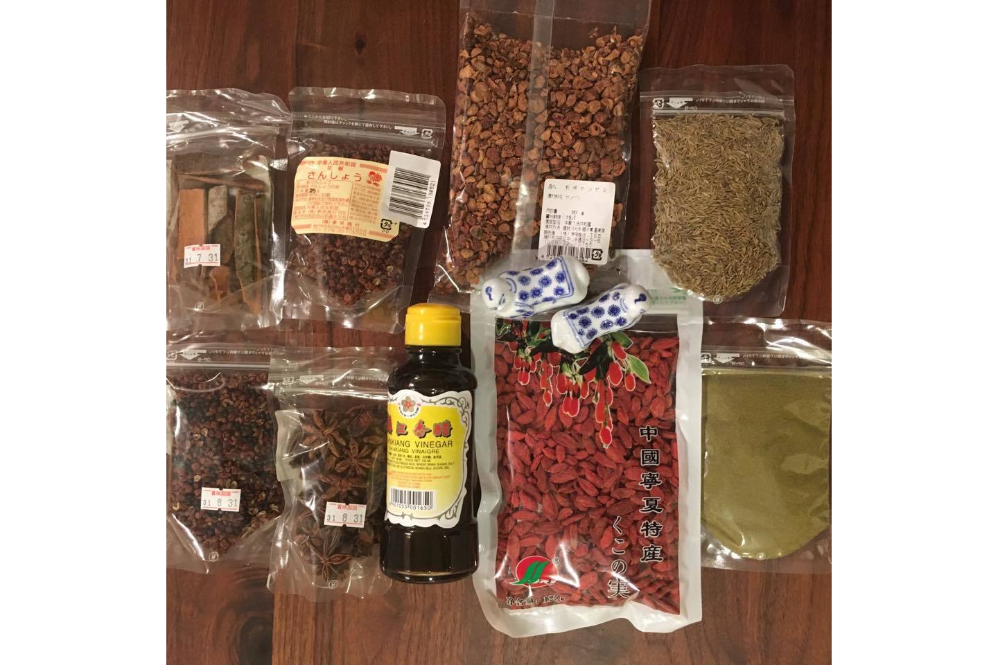 中華食材店で買い求めたスパイスたち。左上が肉桂、その右となりと下がそれぞれ花椒、瓶の酢醤油の左側が八角。オレンジ色の粒がくこの実