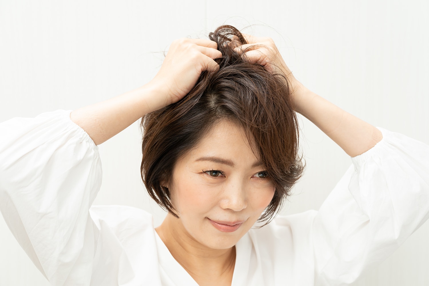頭頂部に高さを出すイメージで、手のひらで握るようにワックスをもみ込む。