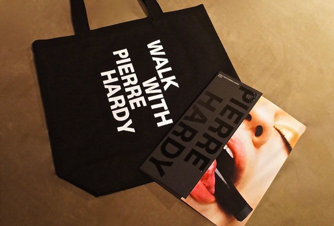 数量限定のトートバッグ¥1,000、すべての作品を収録した「ウォーク ウィズ ピエール アルディ」カタログ¥1,800(ともに税抜)