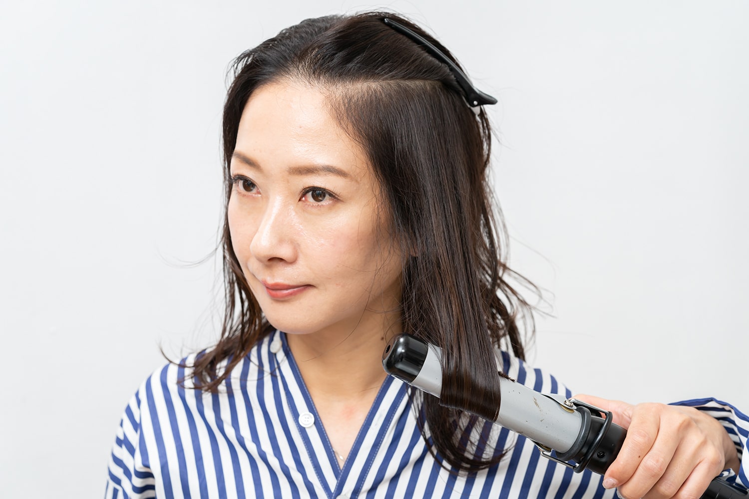 はち周りの髪をピンで留めておくと便利。肩にかかる髪を真っ直ぐおろしながら内巻きに。