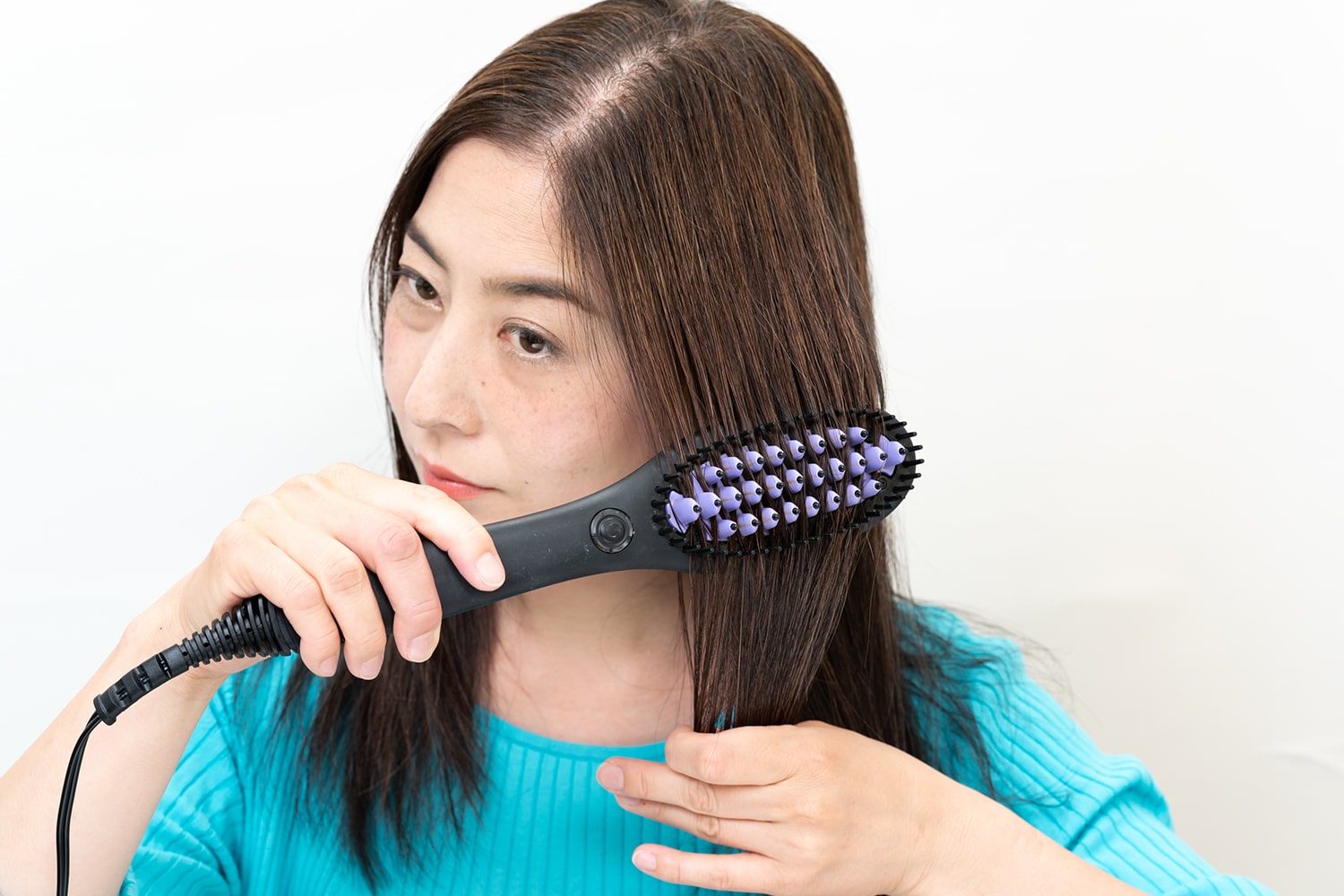 片手で手束の毛先を軽く引っ張りながらブラシを通すと、より真っ直ぐに。