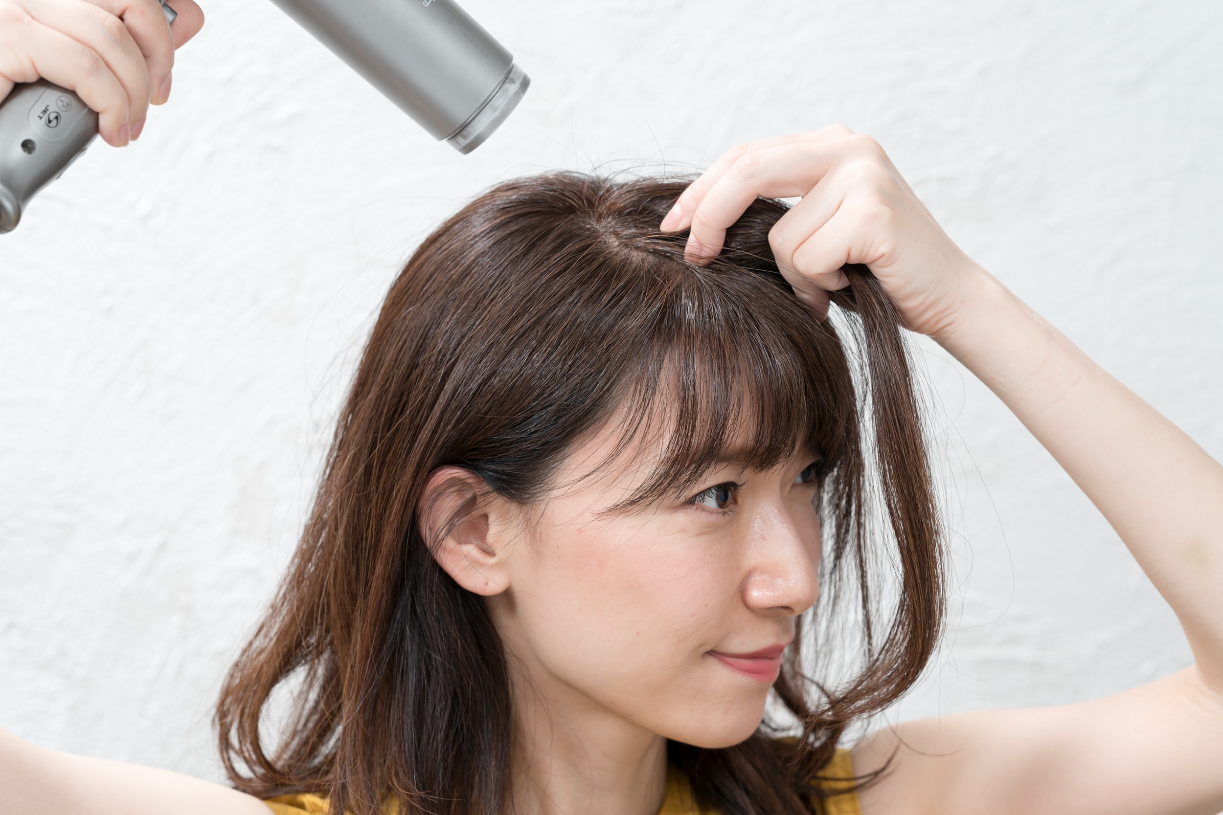 頭頂部の毛束は500円玉分くらいを前に持ってきて根元にドライヤーを当てる。後部から熱を当てるのがコツ。いつもの分け目から5ミリくらいズラして反発させると根元がよく立ちます。