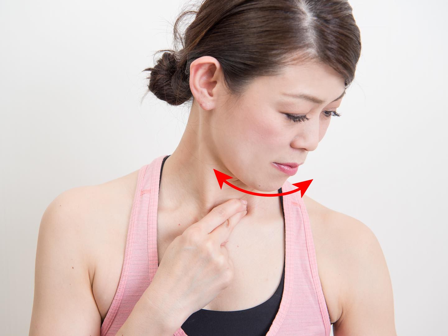 鎖骨の手前を指でプッシュしながら、首を左右に振っている女性