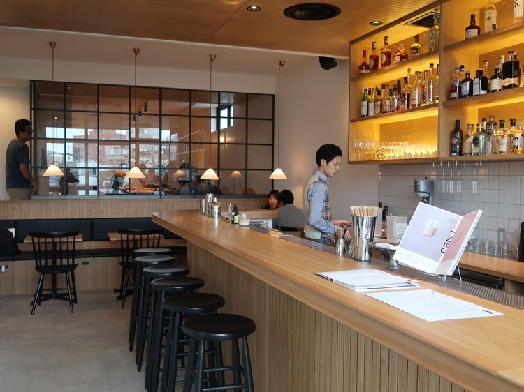 従来のバーの印象とは異なる白とオーク材で統一された店内
