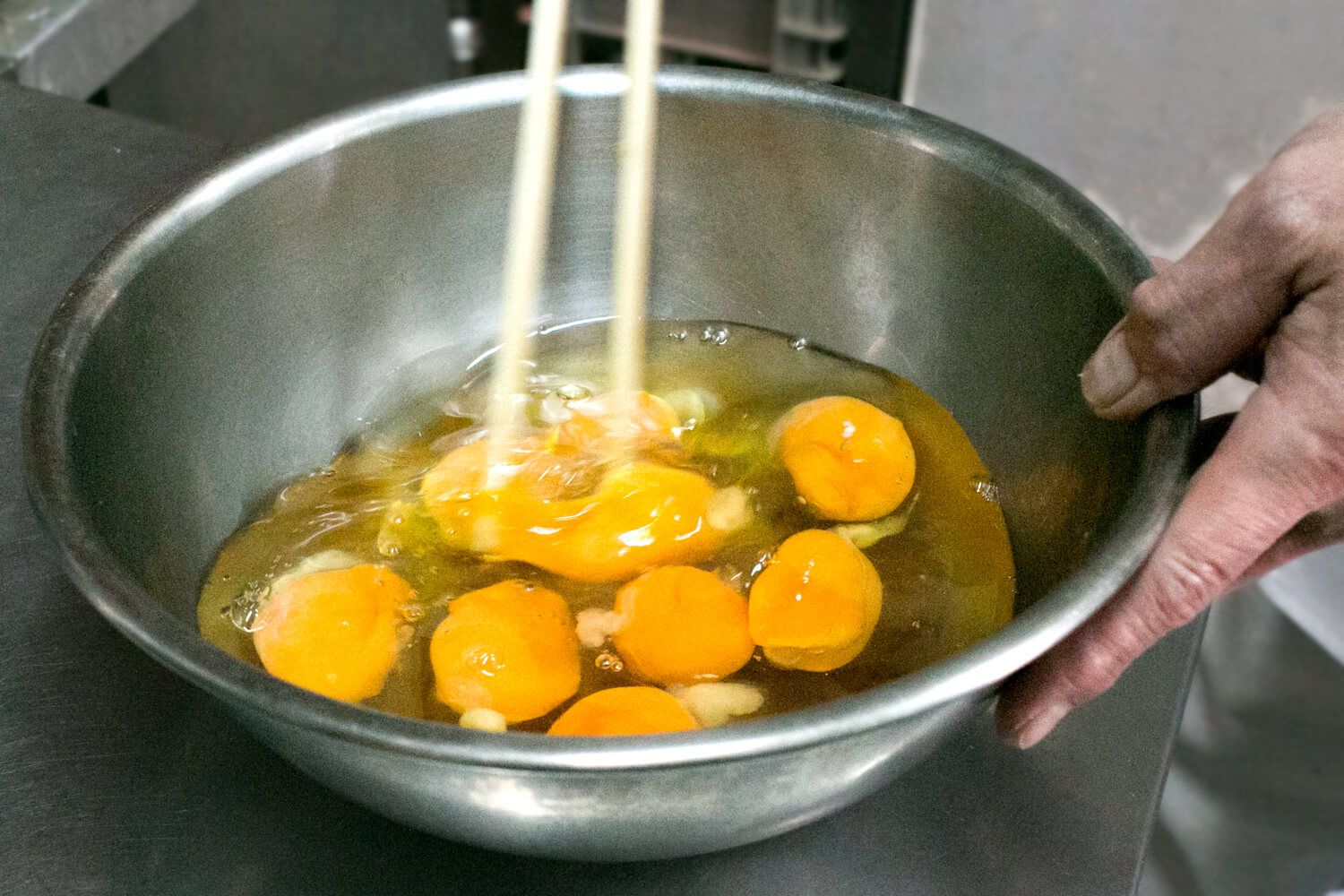 菜箸を使って、左右に白身を切るようにして卵を溶きます