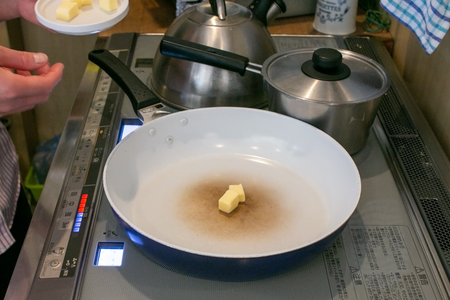 中火で熱したフライパンの中央にキューブ状にカットしたバターをふたつ入れます