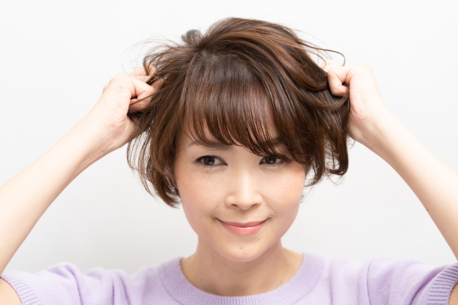 小指の爪くらいのワックスを手のひらになじませ、髪を握るように全体になじませる。
