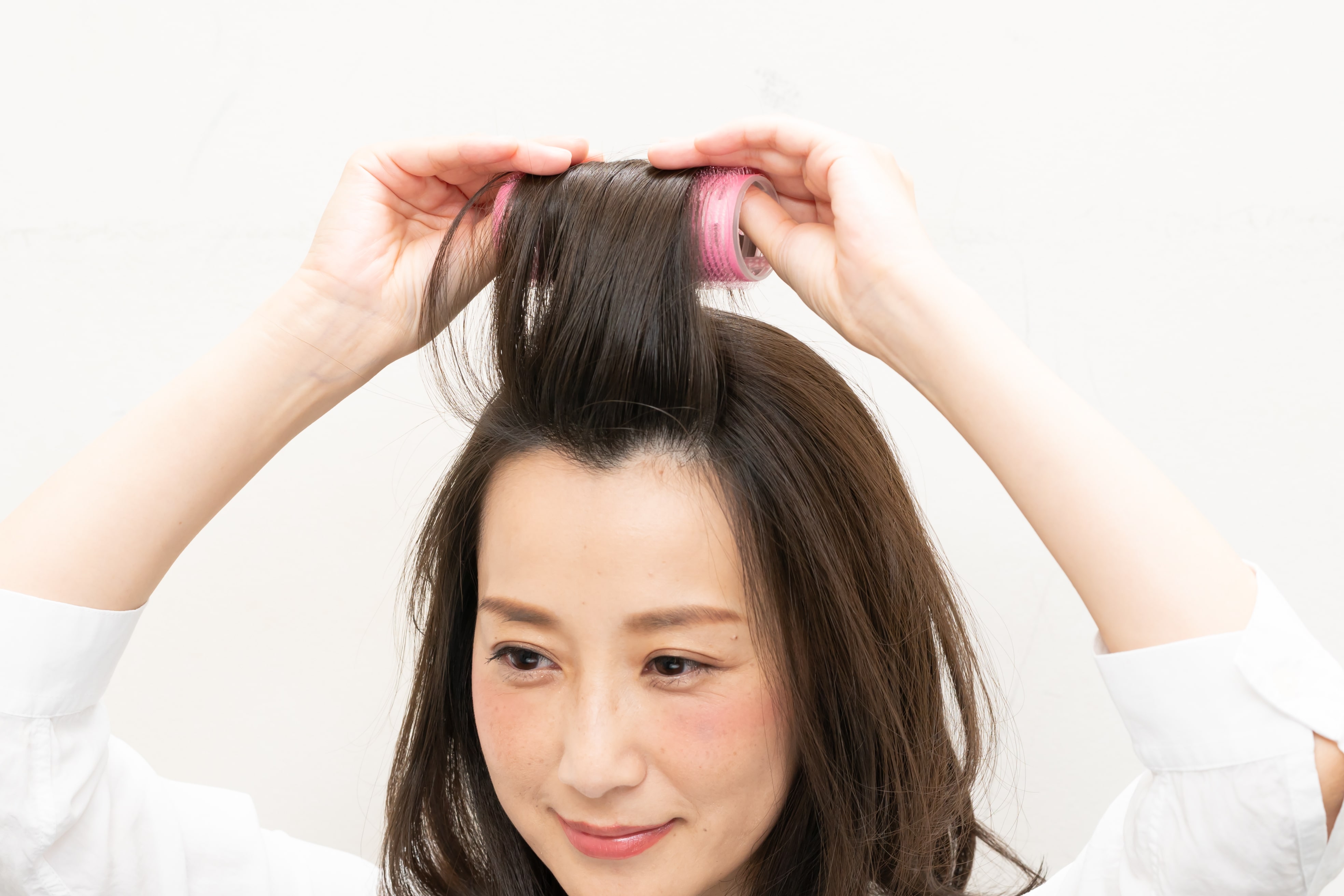 髪の根元を立たせるように真っ直ぐ垂直に持ち上げた状態でカーラーに巻きつけること。