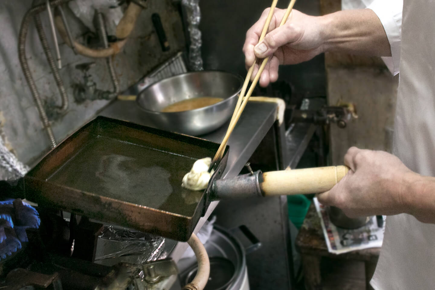 玉子焼き器を中火にかけて温め、油を染み込ませたキッチンペーパーで玉子焼き器の全体に薄く油を敷きます