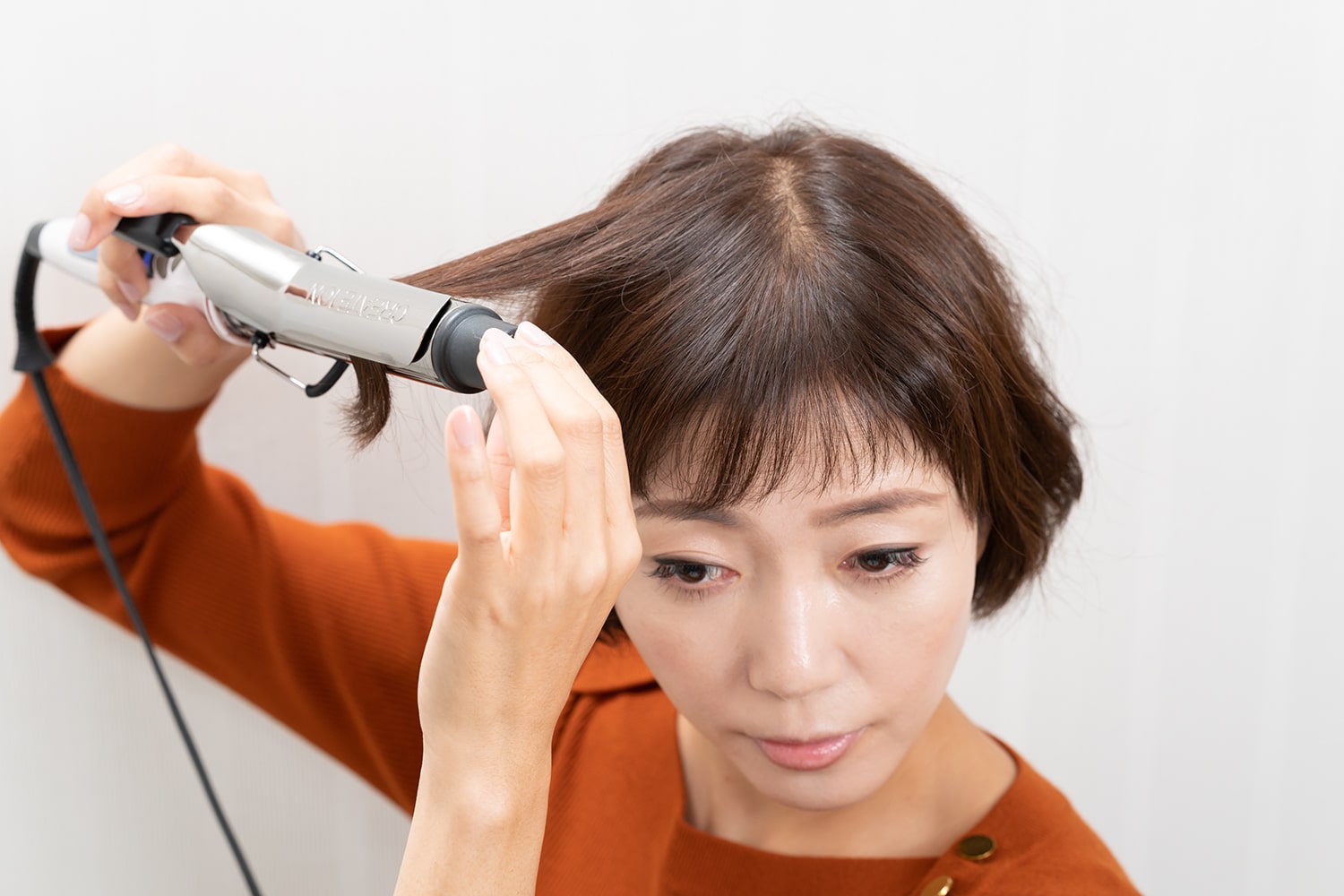 ツヤを出すのが目的なので髪の内側はアイロンをかけなくてOK。毛束の根元を起こすようにカールアイロンを動かすこと