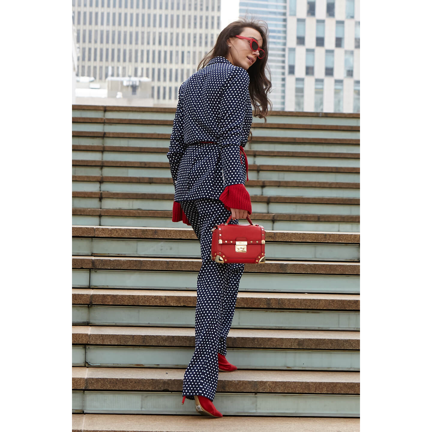 赤いバッグを取り入れたコーディネートの女性