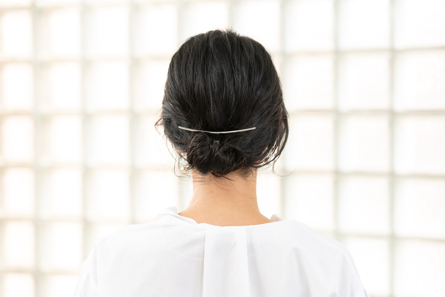 定番のお団子ヘアも、さりげなく見えるコームで上級者の装いへ