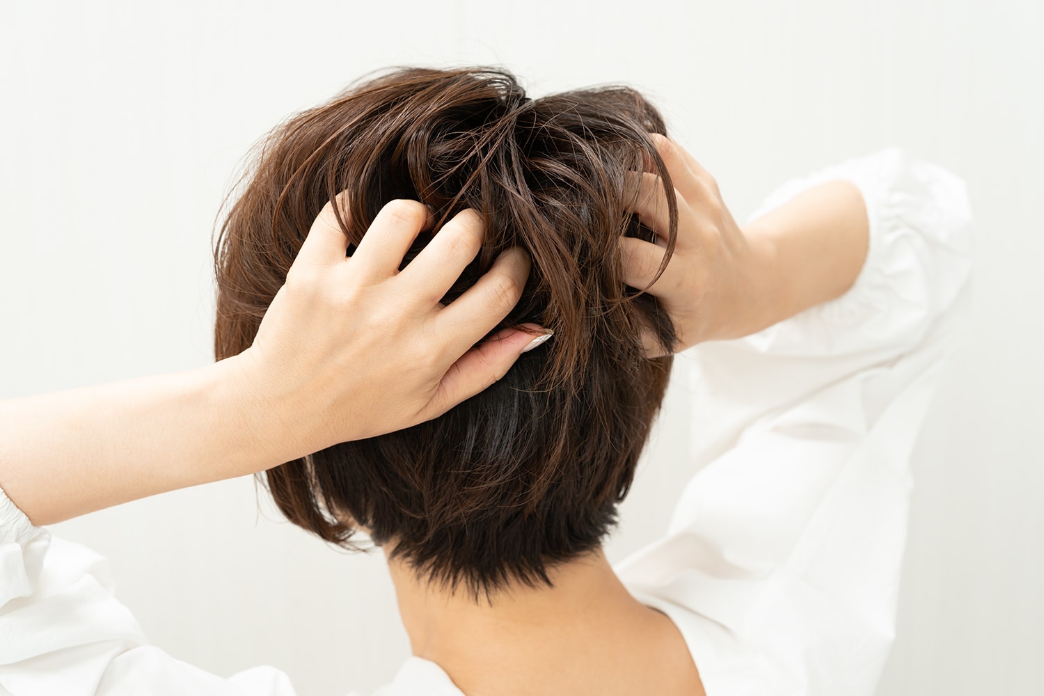 パール粒ふたつ分くらいのワックスを手のひらに伸ばし、後頭部に膨らみをつくるようにもみ込む。
