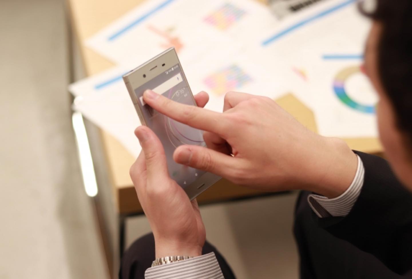 スマートフォンでフリック入力をしている男性