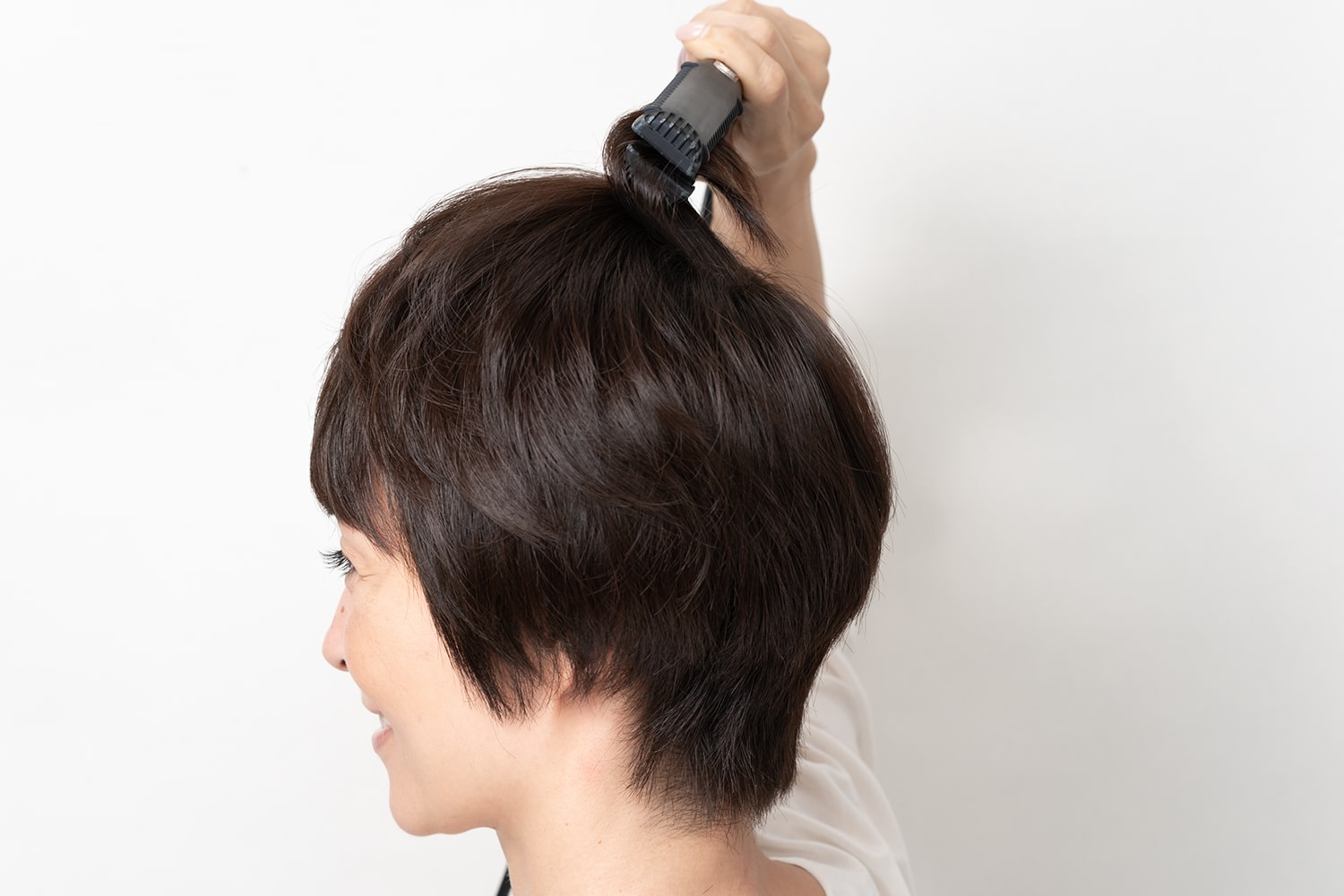 毛束の根元を起こすようにアイロンを動かし、毛先だけ内巻きにする。