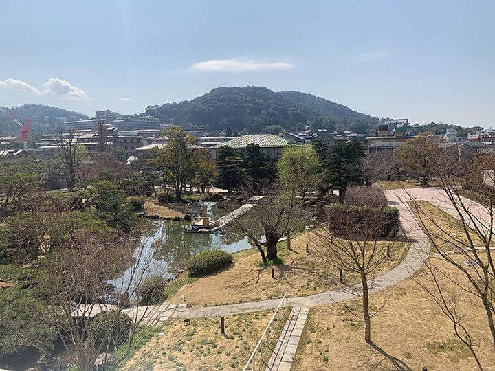 日本庭園を見下ろす屋上テラス。遠くには雄大な東山が広がっている。美術館の隣には動物園があり、キリンが見えることも。