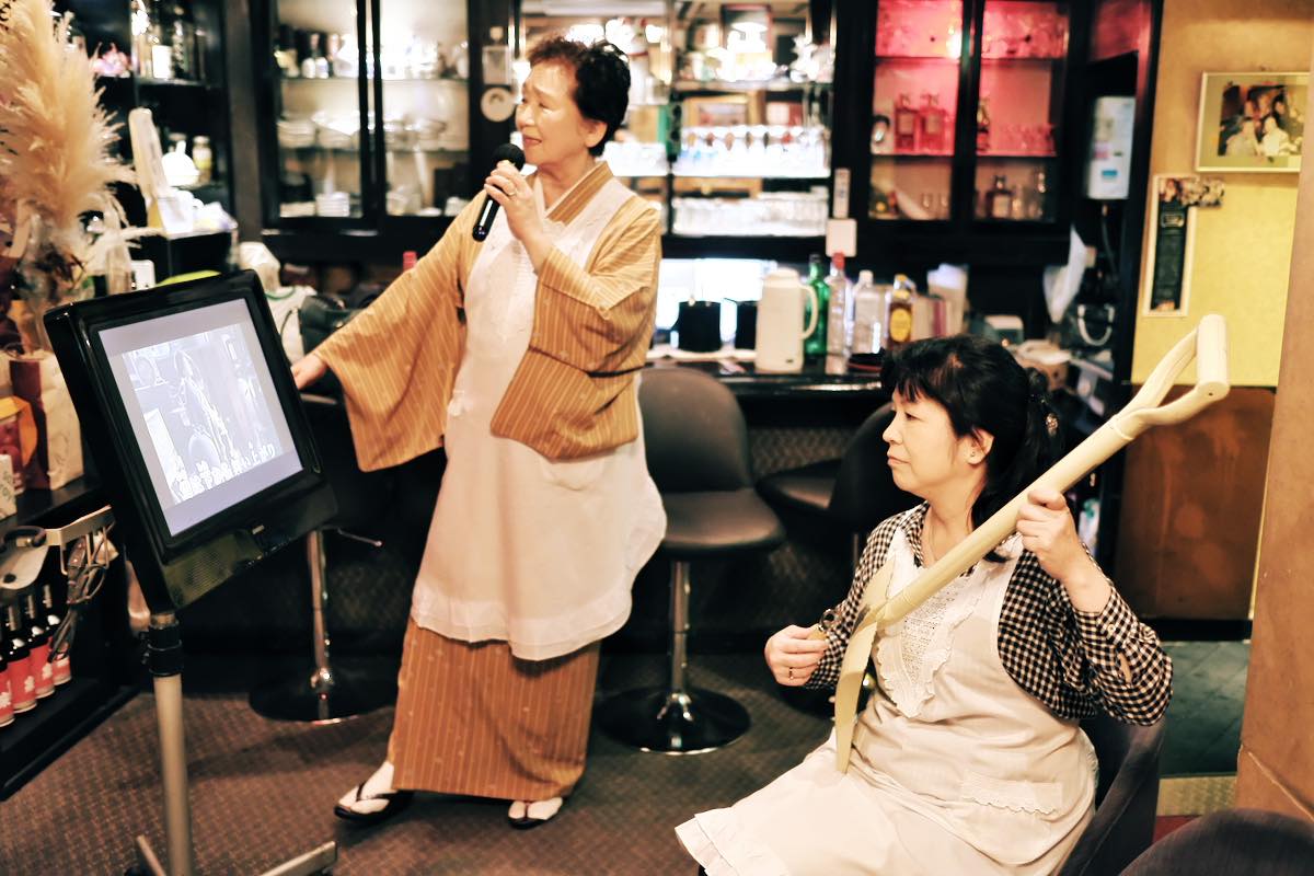スコップ三味線を弾く雅子さんと歌う仁子ママ