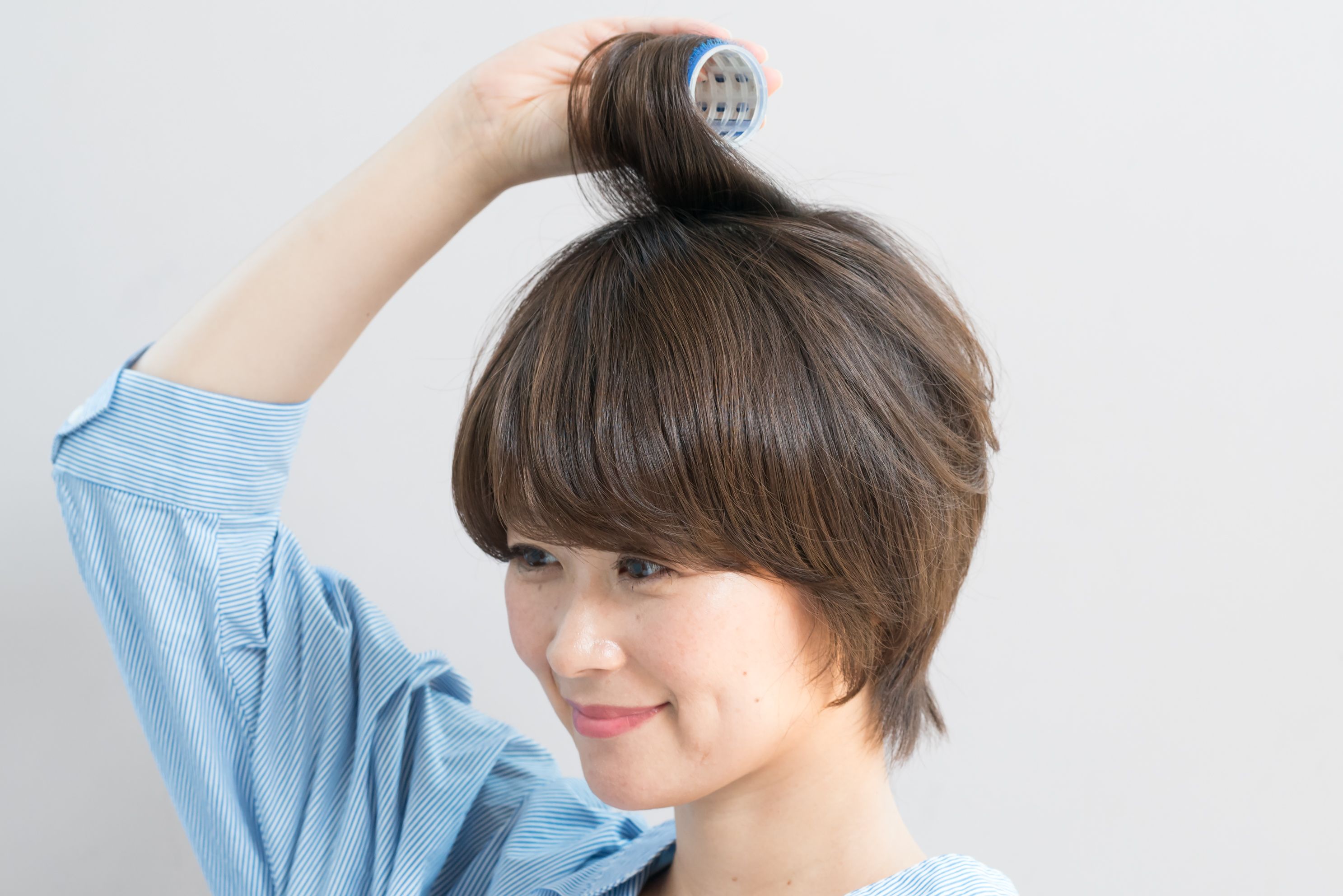頭頂部の中心から半径5㎝くらいの髪をざっくりと取ってカーラーに巻きつける。前髪も少し巻き込んでおくと、前髪にも動きが出る。