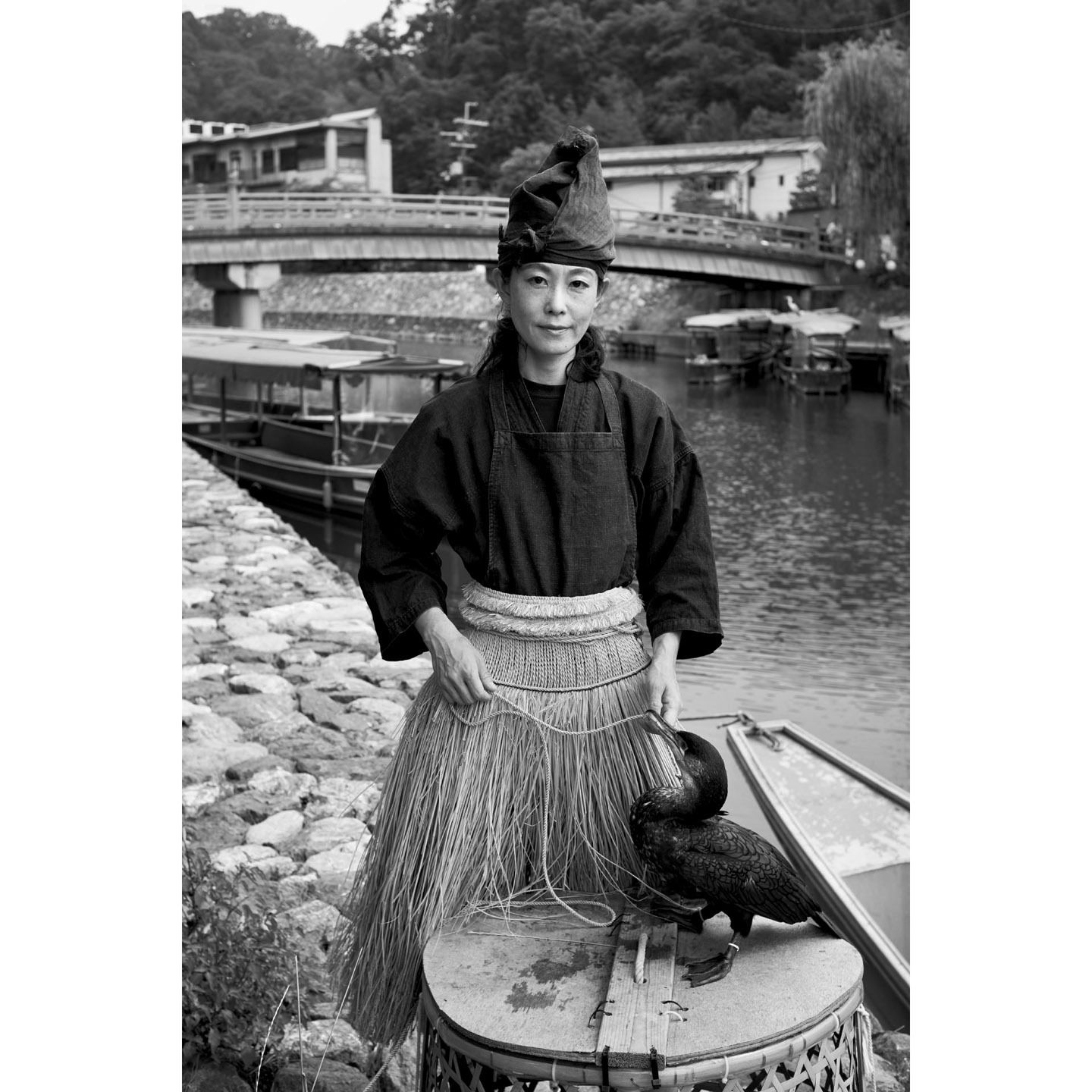 宇治川の鵜飼・鵜匠の澤木万理子さん。宇治川沿いの鵜小屋前で、宇治で生まれた「ウッティー」とともに