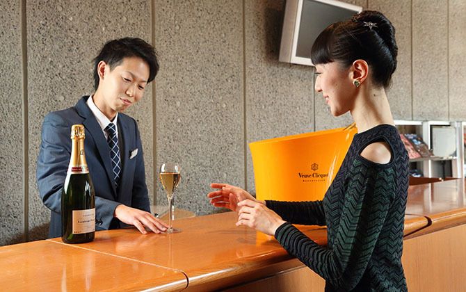 シャンパンを受け取るプリンシパルの米沢唯さん