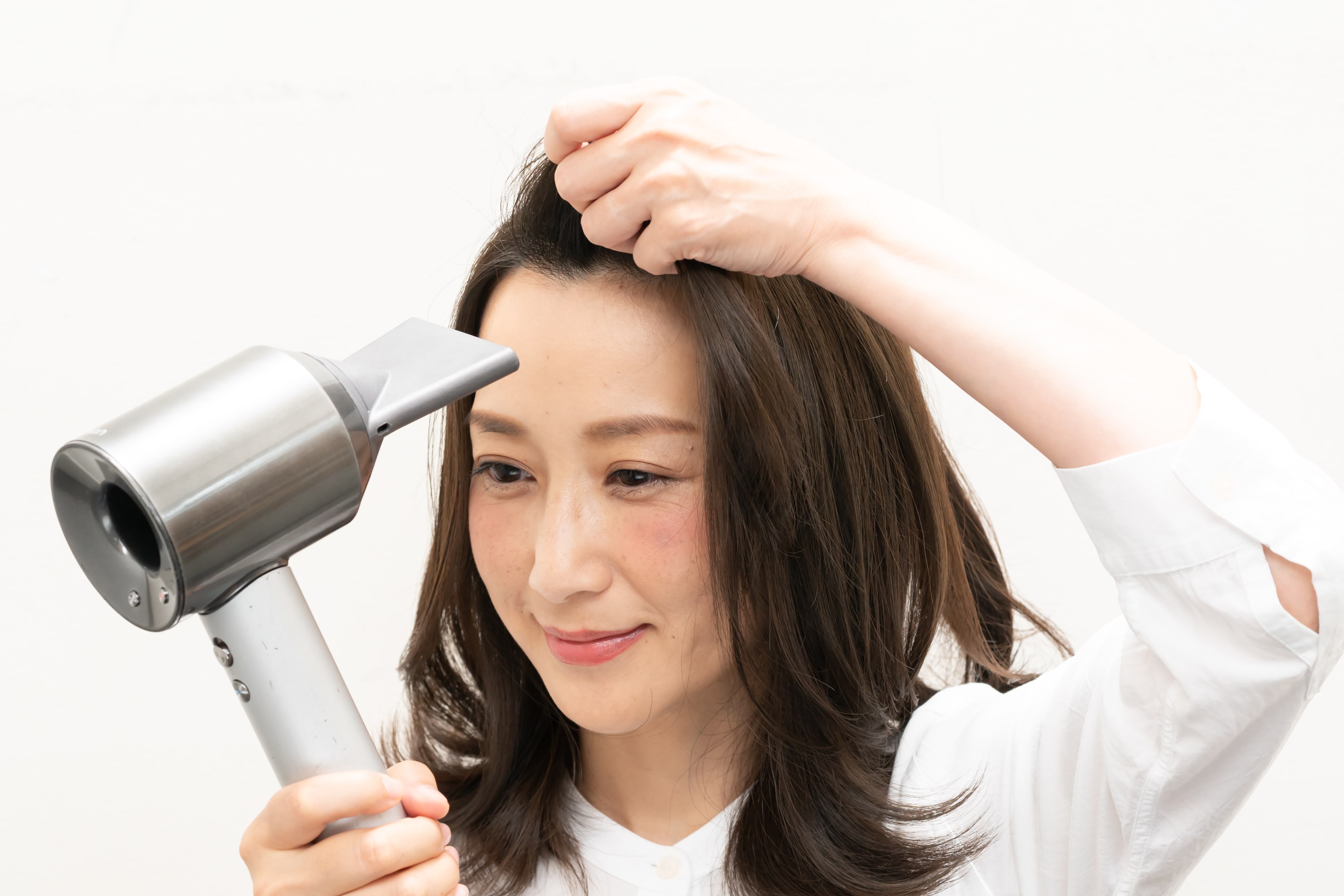 前髪を軽く握り、根元にドライヤーをあてるのがコツ。