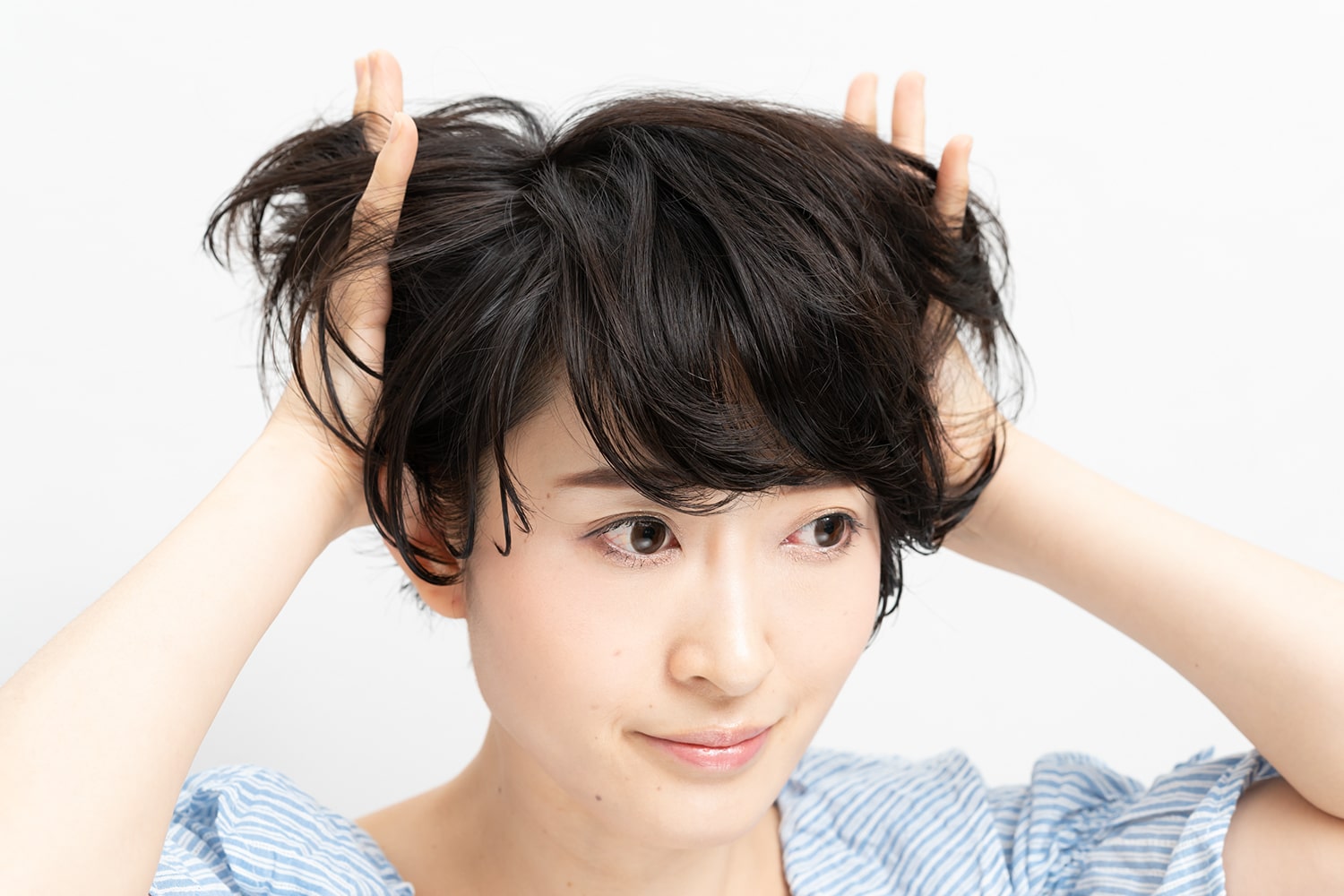 髪の根元から全体にワックスをなじませる。