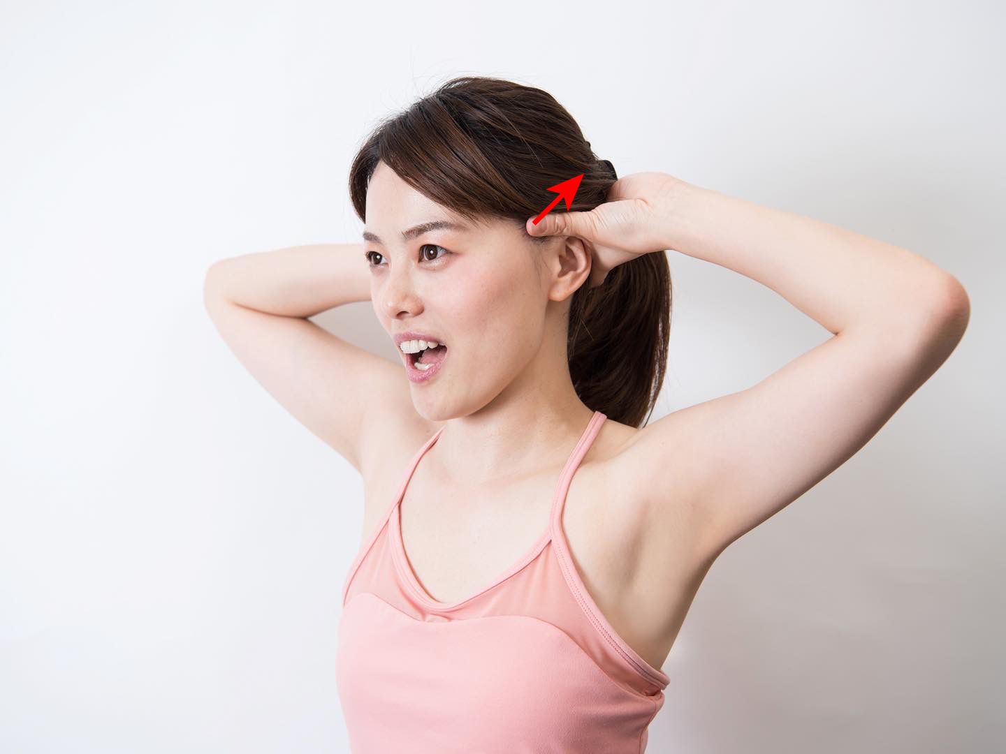 頭皮マッサージしながら口を開閉している女性