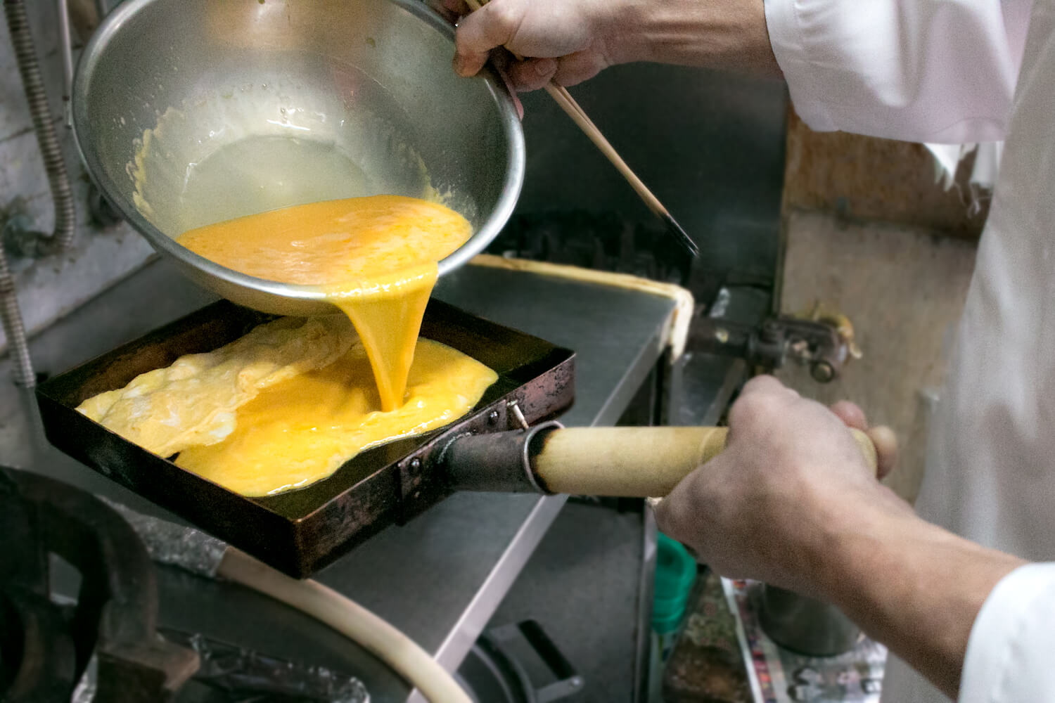 巻いた玉子焼きを奥に戻し、手前部分に卵液を流し入れます
