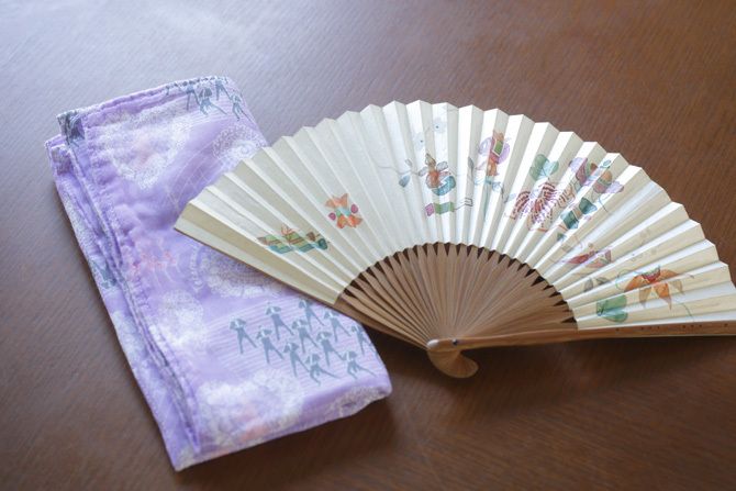 いつもバッグに入れているという奈良の『白雪ふきん』の大判サイズのハンカチと、京都の『宮脇賣扇庵』の扇子。「大判サイズのハンカチは、食事をいただく際に膝掛けとしても利用しています。よく見ると、私の大好きな宝塚歌劇の柄なんですよ」