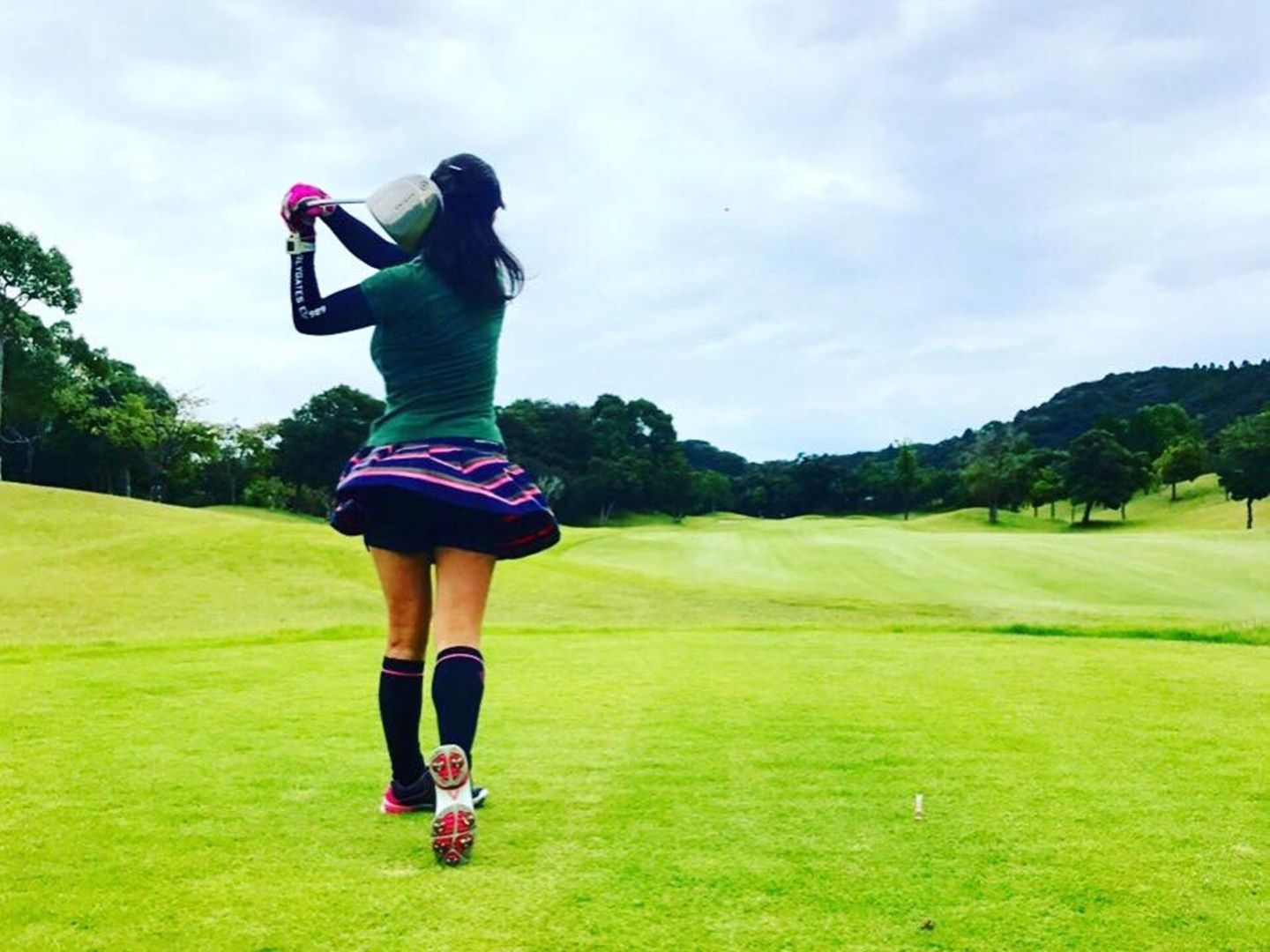 ゴルフ場で思いきりゴルフクラブを振っている安田さん