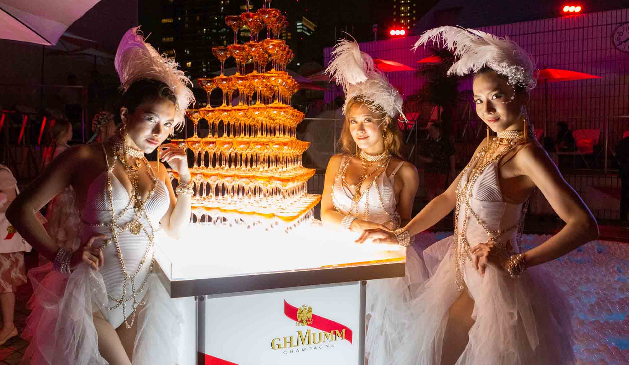 こちらもプール開きイベントで撮影された一枚。シャンパンタワーと美女の競演だ。