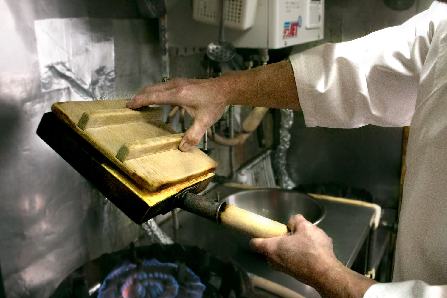 1/2幅で手前に巻いた玉子焼きの上から蓋を当てます