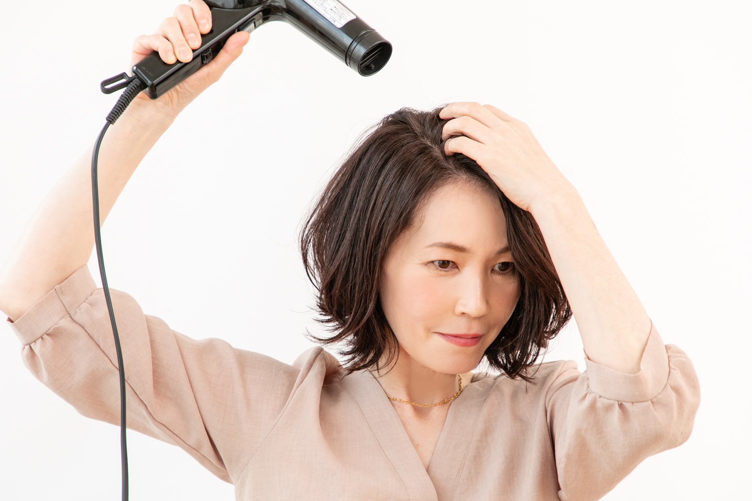 根元から乾かす。トップはドライヤーの風を後ろから前に向かって当て、分け目を消すように根元を擦りながらドライ。
