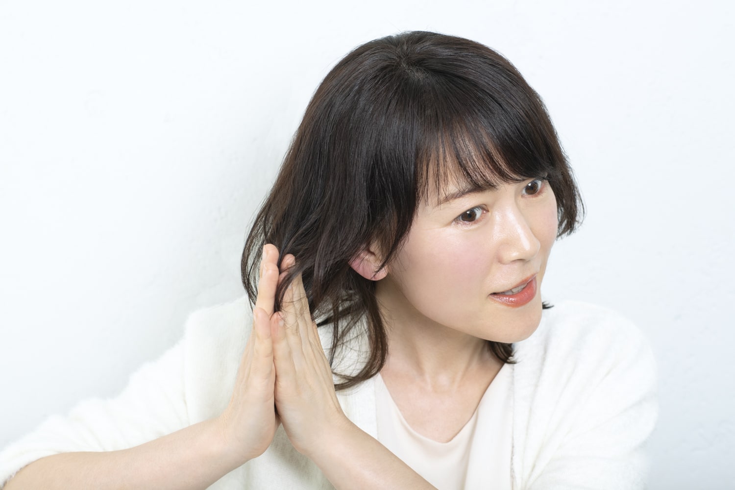 中間~毛先にノーマルタイプのワックスをなじませる。手のひらを合わせて擦り合わせるようにすると束感ができる。