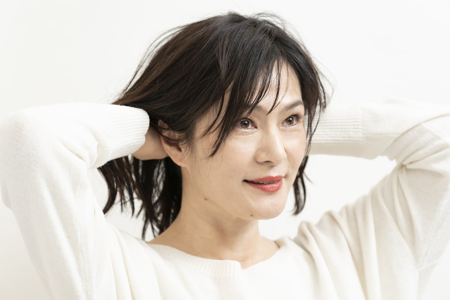手のひらにオイルを広げ、髪をかき上げるようになじませること。