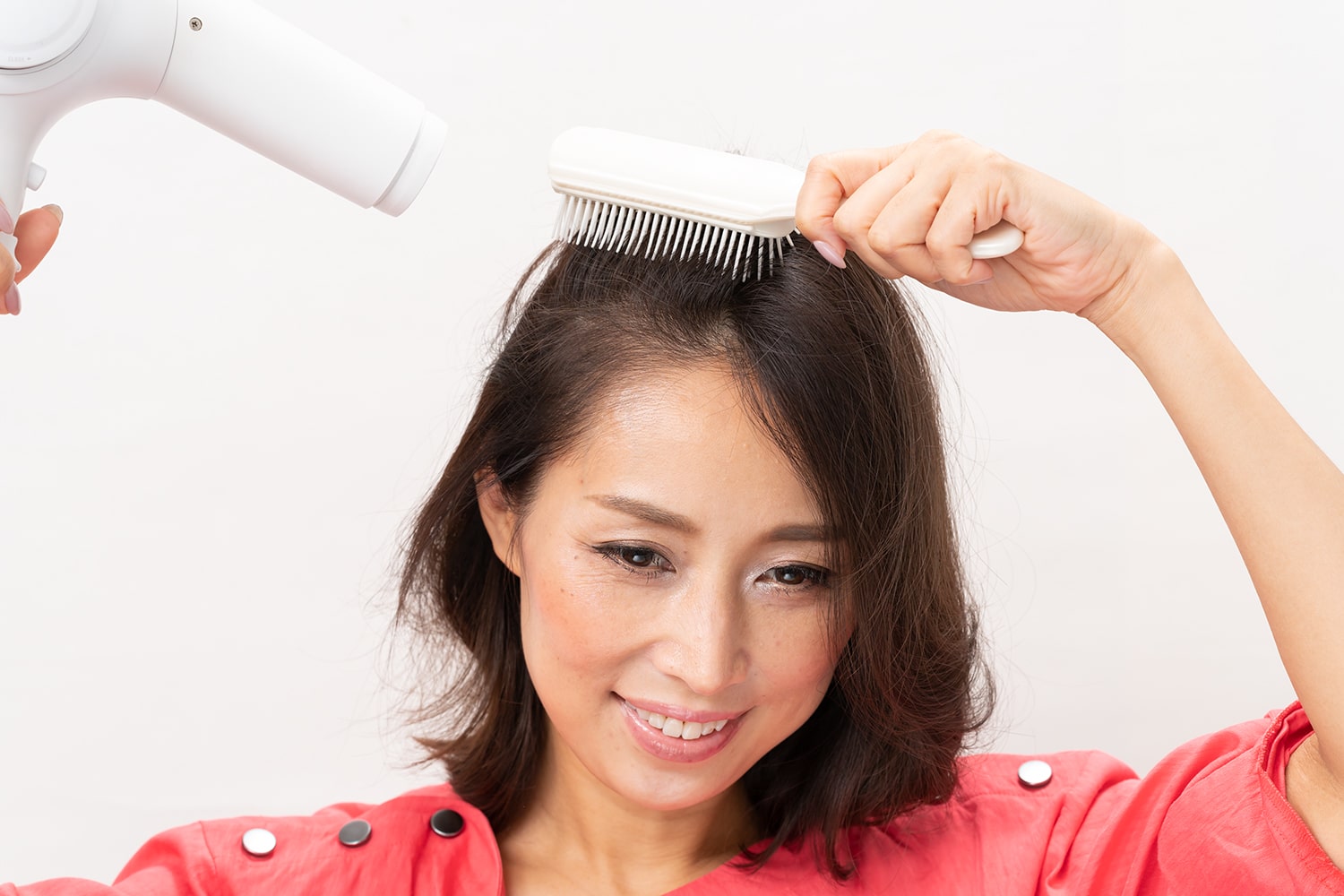 髪と頭皮が濡れているうちに、ドライヤーとブラシで生えグセを正すようにとかしながら乾かす。