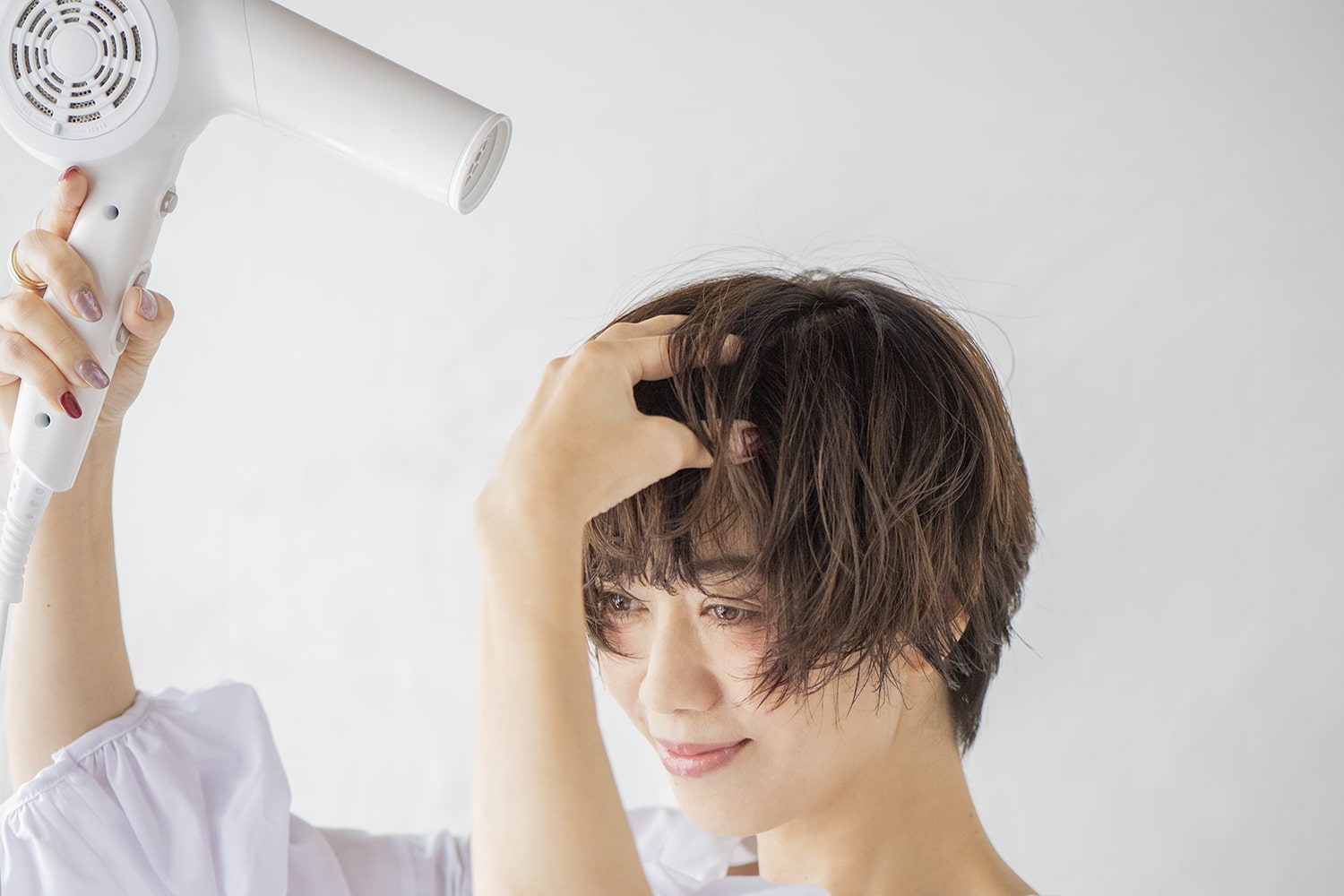 自然と後ろに流れるように仕上げるため、まずは根元を前向きに乾かしてクセを軽減。