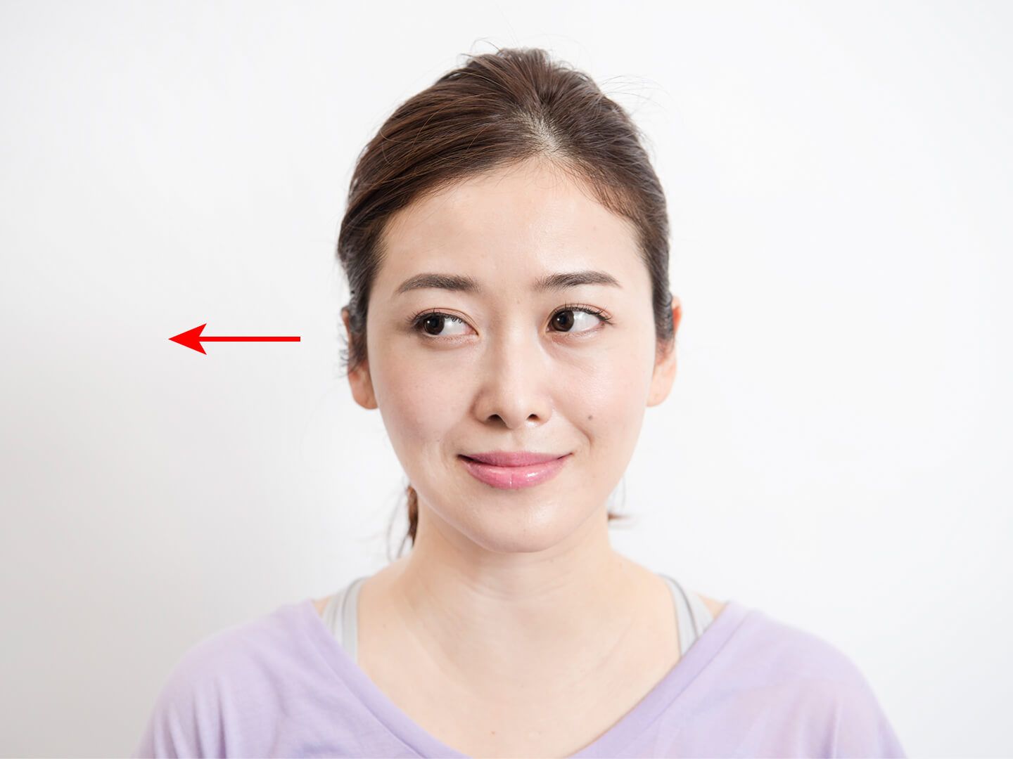 右方向に目を動かしている女性