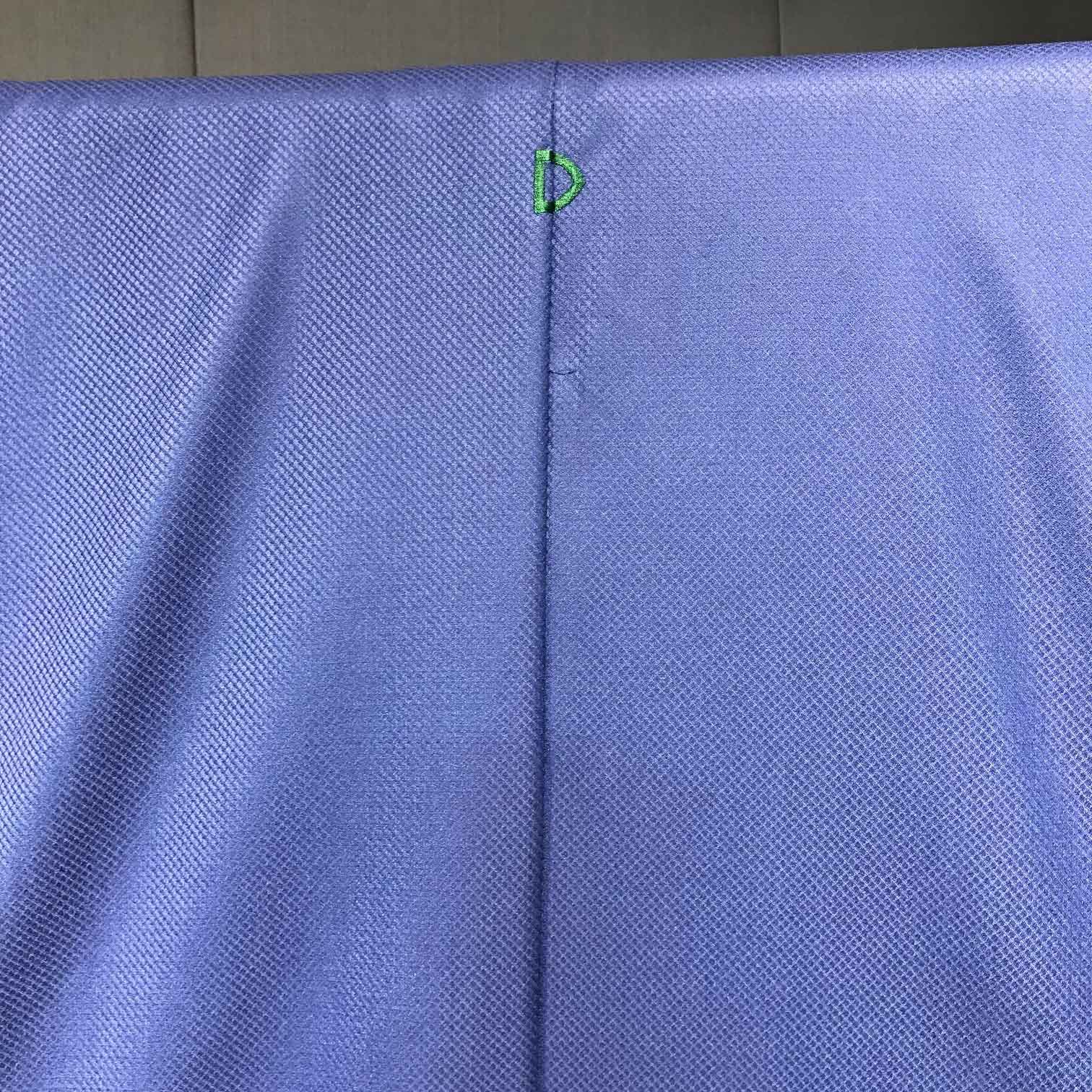 着物の後身頃の正中線に「ドーメル」のイニシャルを刺繍。ブルーの服地に対し、爽やかなグリーンが穏やかに対比する。
