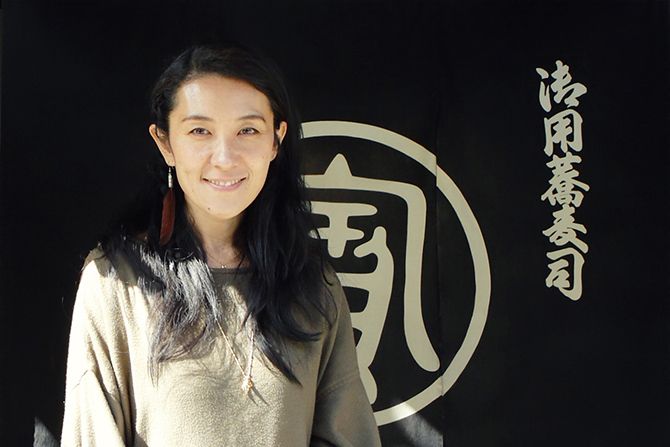のれんの前に立つ稲岡亜里子さん