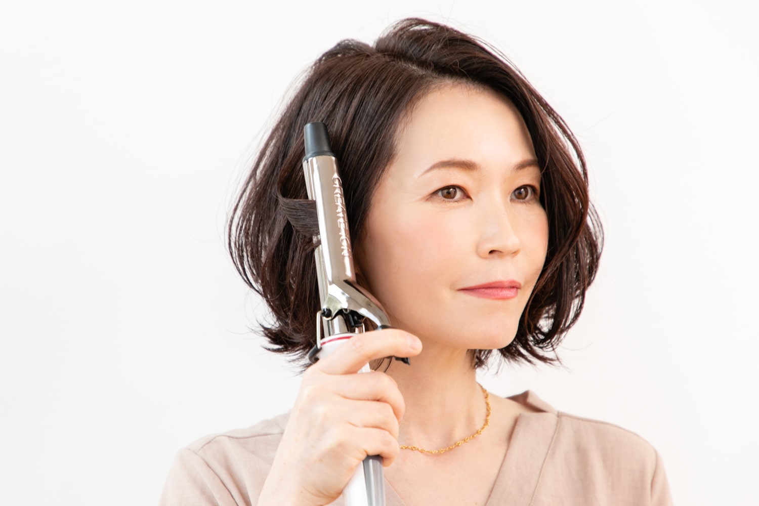 26mmのヘアアイロンを使用。表面の髪は中間から内巻きに1回転、毛先は外ハネになるように巻く。前髪は中間から外巻きに。