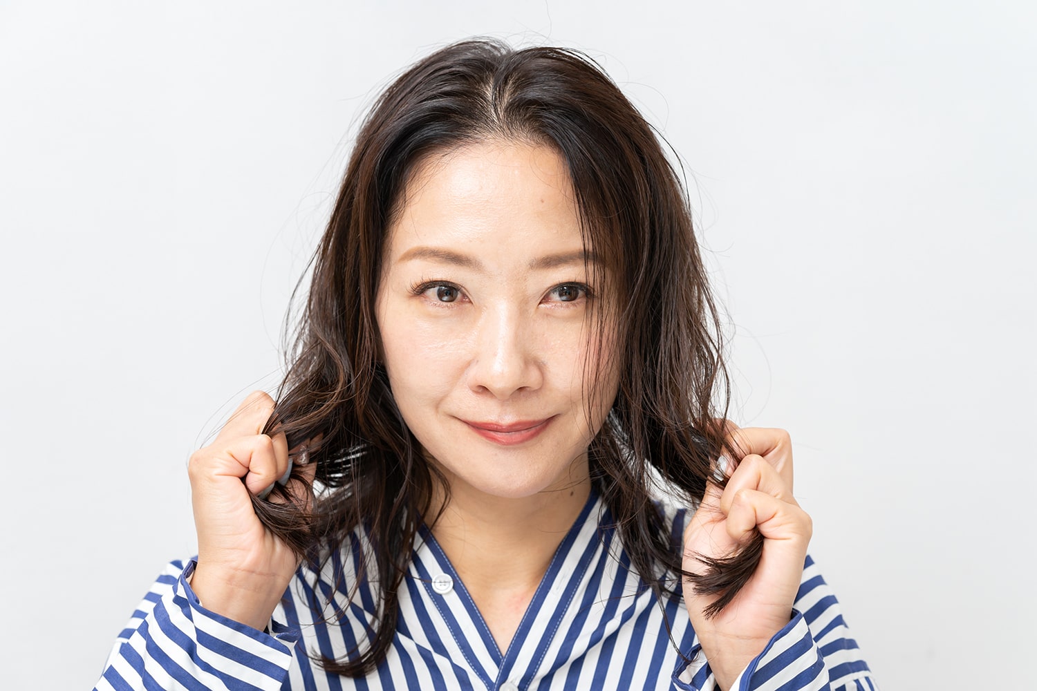 両手のひらにバームを広げ、毛先を握るようにしてなじませる。