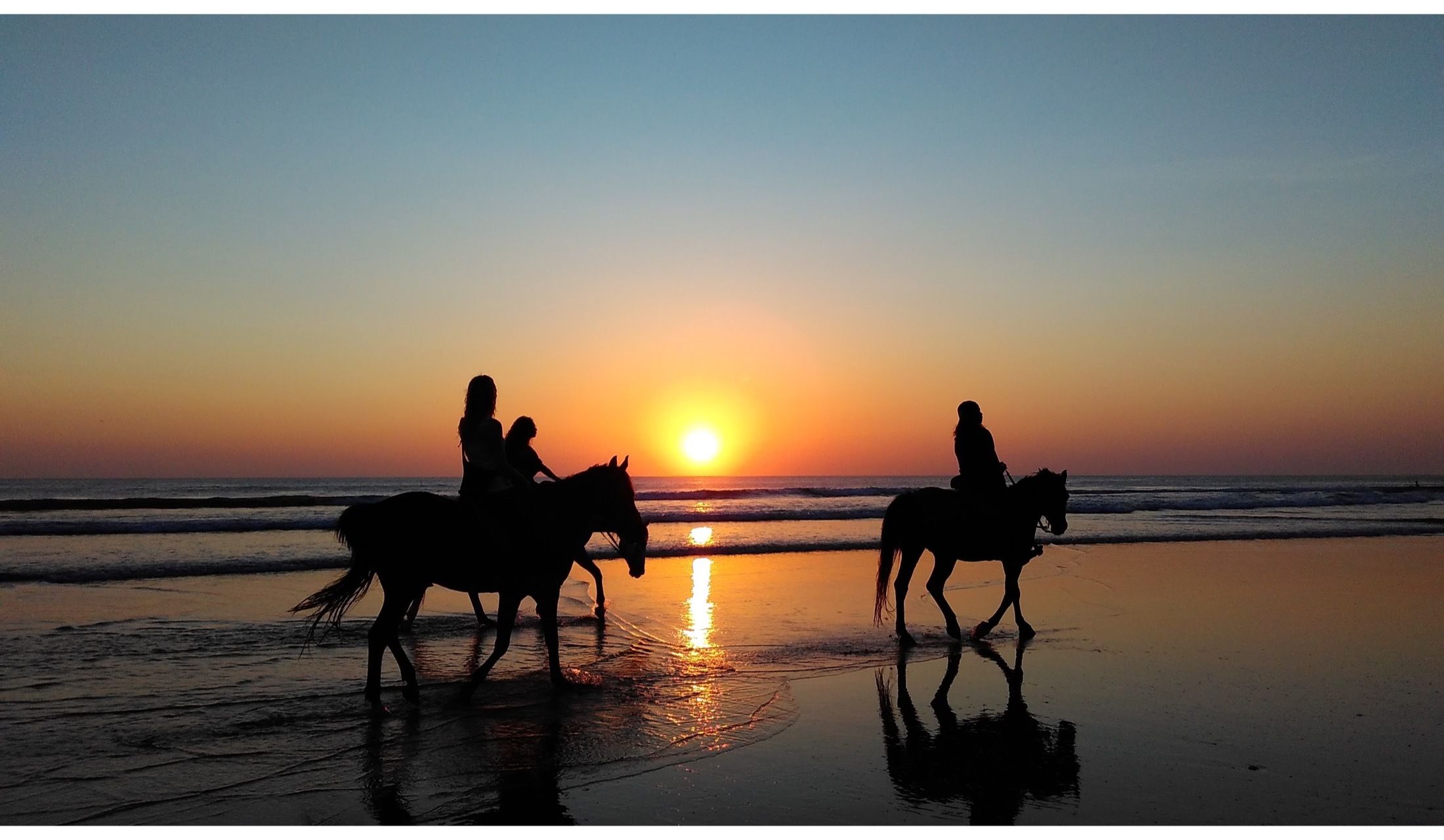 海辺の夕焼けを見ながらの乗馬